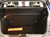 the back of a blue car with its trunk open and a seat folded down