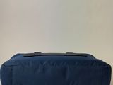 the back of a blue bag sitting on top of a white table