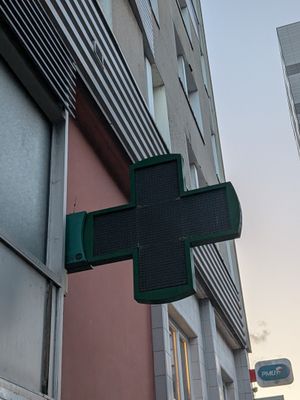 a green cross sign on the side of a building