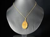 un collier en or avec un pendentif jaune sur un mannequin noir