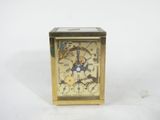 a small gold clock with a clock face on it