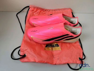 des baskets roses dans un sac en toile, posées sur une surface blanche