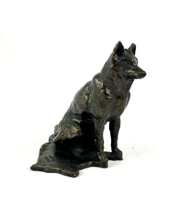une statue représentant un chien assis par terre