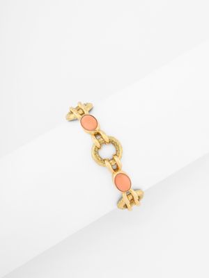 an image of a gold and coral bracelet on a napkin