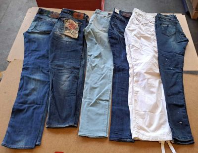 Plusieurs paires de jeans sont disposées sur une boîte en carton