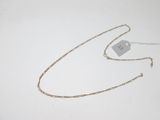 a gold chain with a tag attached to it on a white surface