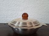 a metal bowl with a wooden ball on top of it