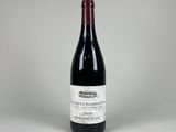 une bouteille de vin rouge posée sur une table blanche