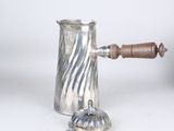 a silver coffee pot with a wooden handle on a white table
