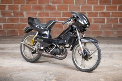 a black motorcycle parked in front of a brick wall
