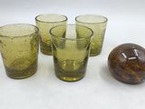 Plusieurs verres et une balle sont posés sur une surface blanche.