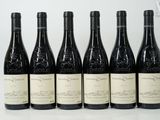 six bottles of wine are lined up in a row on a table