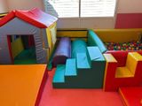 brightly colored play area with soft play equipment and soft play house