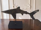 sculpture of a shark on a stand on a wooden table