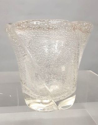 a glass vase that is sitting on a clear table