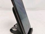 a close up of a cell phone on a stand on a white surface