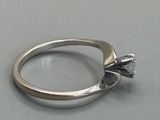 a silver ring with a diamond in it on a table