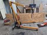 une grue qui se trouve dans un garage avec des outils