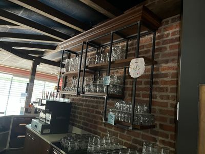 de nombreux verres sur les étagères au-dessus du bar