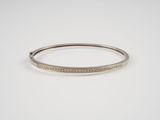 un bracelet rigide en or blanc serti de diamants sur fond blanc