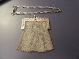 a silver purse with a chain around it on a table