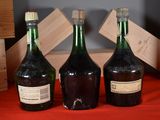 three bottles of wine sitting on a red table cloth