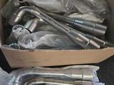 une caisse remplie de tuyaux métalliques et de flexibles