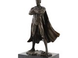 bronze statue of a man in a cape and cloak standing on a marble base
