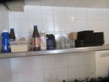 many bottles and containers on the shelf in the kitchen