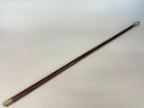 a wooden stick with a metal handle sitting on a white surface