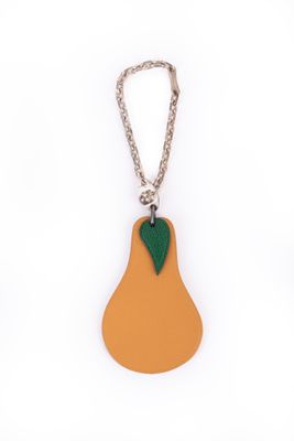 a close up of a key chain with a pear on it