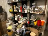 a room with a shelf full of dishes and other items
