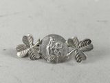a close up of a silver broochle with leaves on it