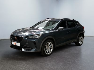 Une voiture noire est garée dans une pièce aux murs blancs.