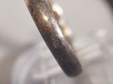 a close up of a silver ring on a stand