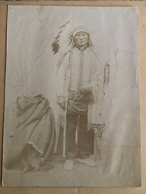 an old photo of a man dressed in native clothing