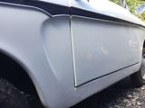 a close up of a white car with a black stripe on the side