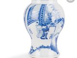 un vase bleu et blanc avec la photo d'une femme dessus