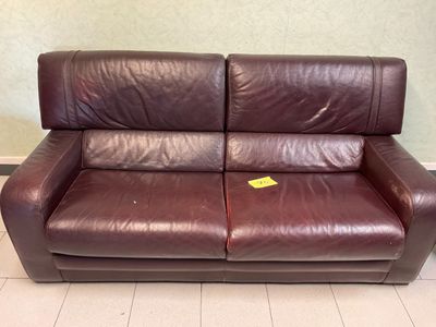 a brown leather couch with a yellow tag on it