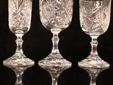 four wine glasses are lined up in a row on a black surface