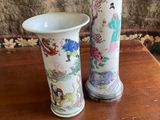 two vases sitting on a table with flowers in them
