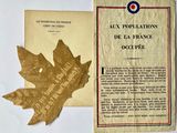 an old book with a leaf on top of it next to a booklet with a picture of a maple leaf on it