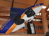 un kayak bleu et orange posé sur une étagère en bois