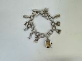 a silver bracelet with charms on it on a white surface