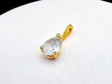 a close up of a gold plated pendant with a clear quartz stone