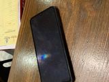 un téléphone portable posé sur une table, à côté d'un stylo et d'une feuille de papier