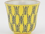 une tasse jaune avec une inscription bleue sur fond blanc