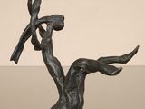 bronze sculpture of a woman holding a bird on a branch