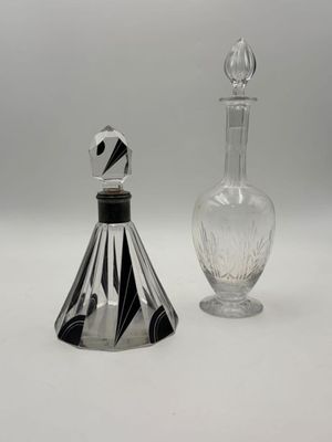 a glass bottle and a glass decanter on a white surface