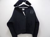 a black hoodie hanging on a hanger on a white wall